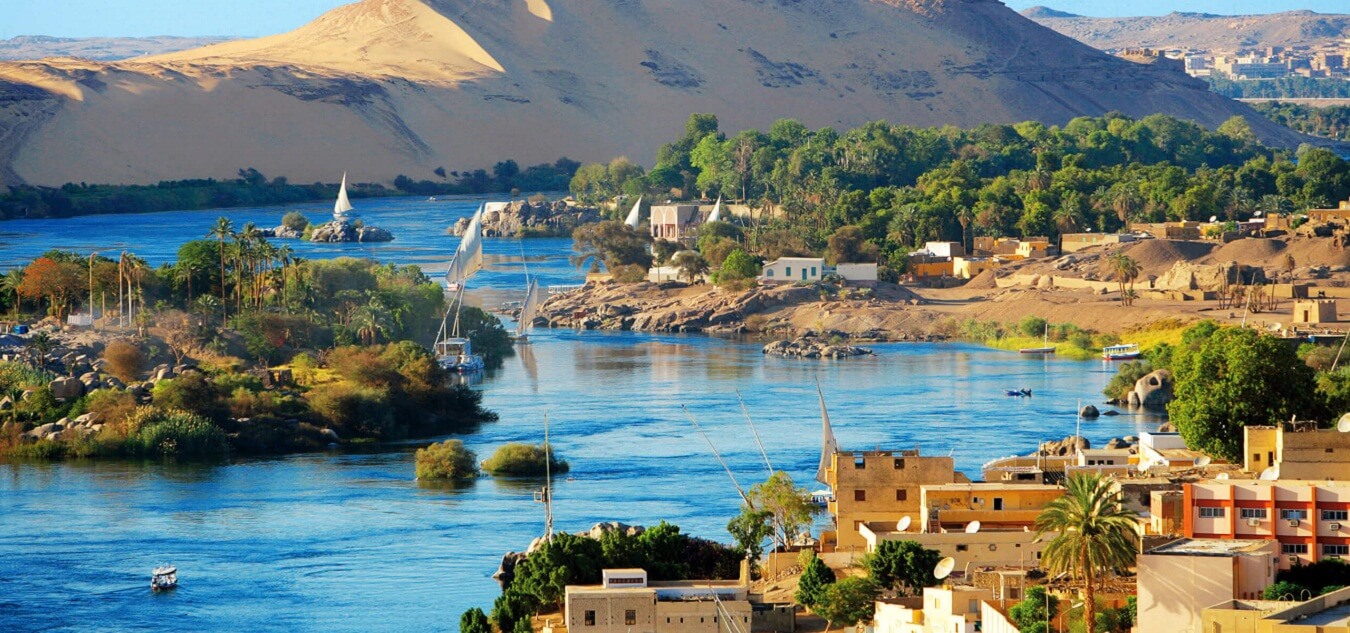 A river with houses and trees in the background.