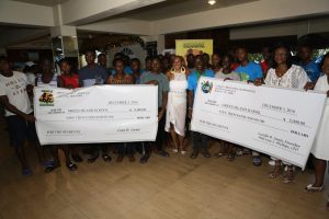 A group of people holding giant cheques in front of each other.