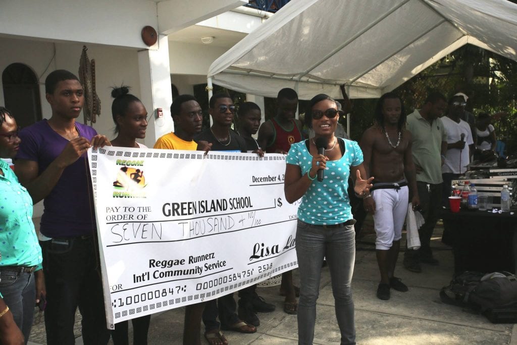 A woman holding up a giant check in front of a group.