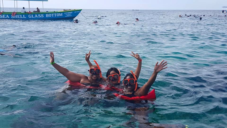 Three people in the water with life jackets on