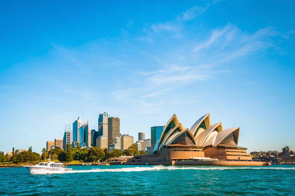 A view of the sydney opera house from across the water.