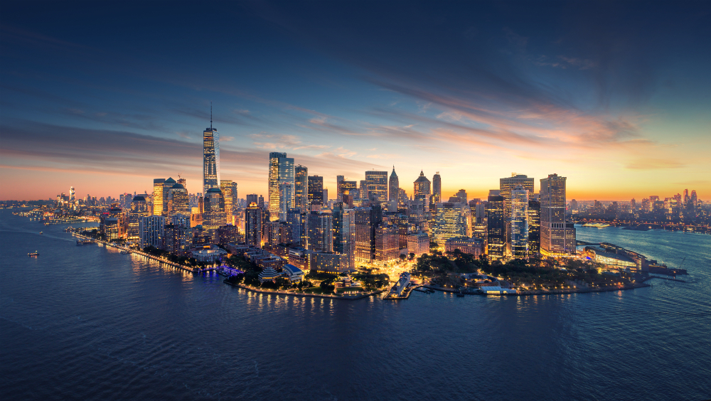 A city skyline with lights and water at night.
