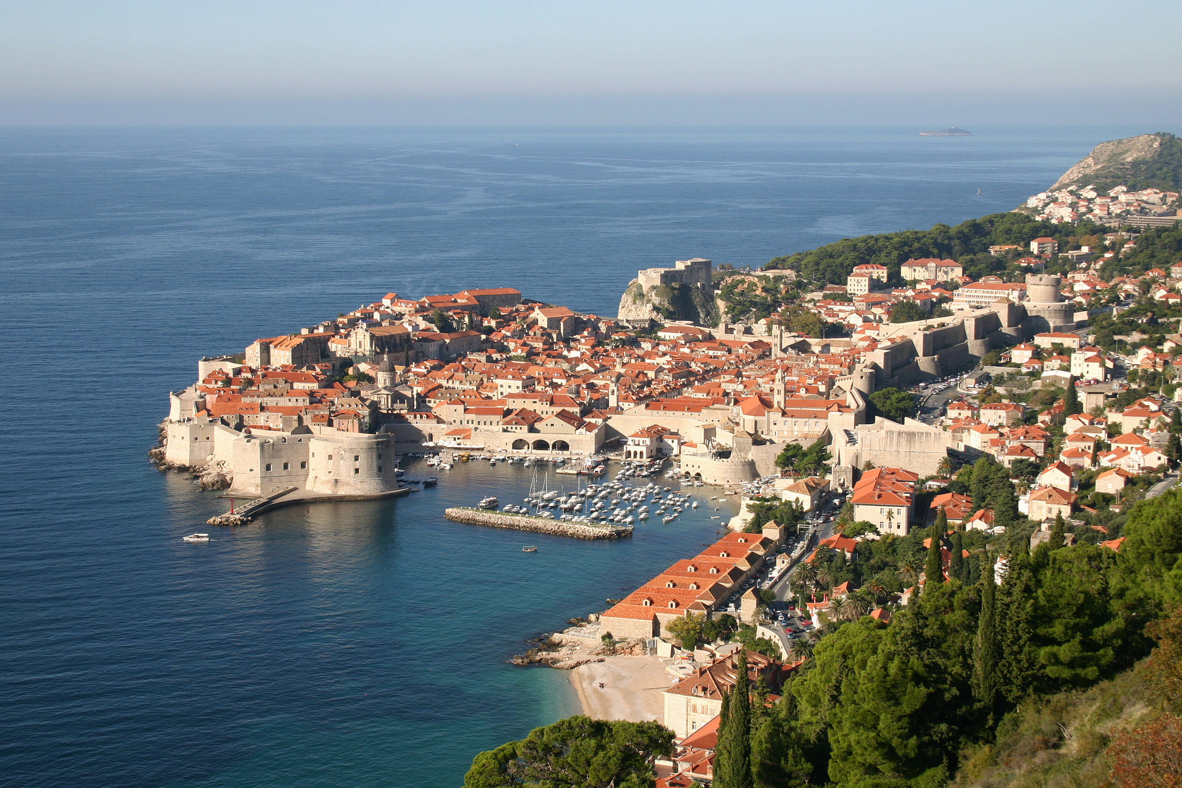 A view of the sea from above, with buildings and boats in it.